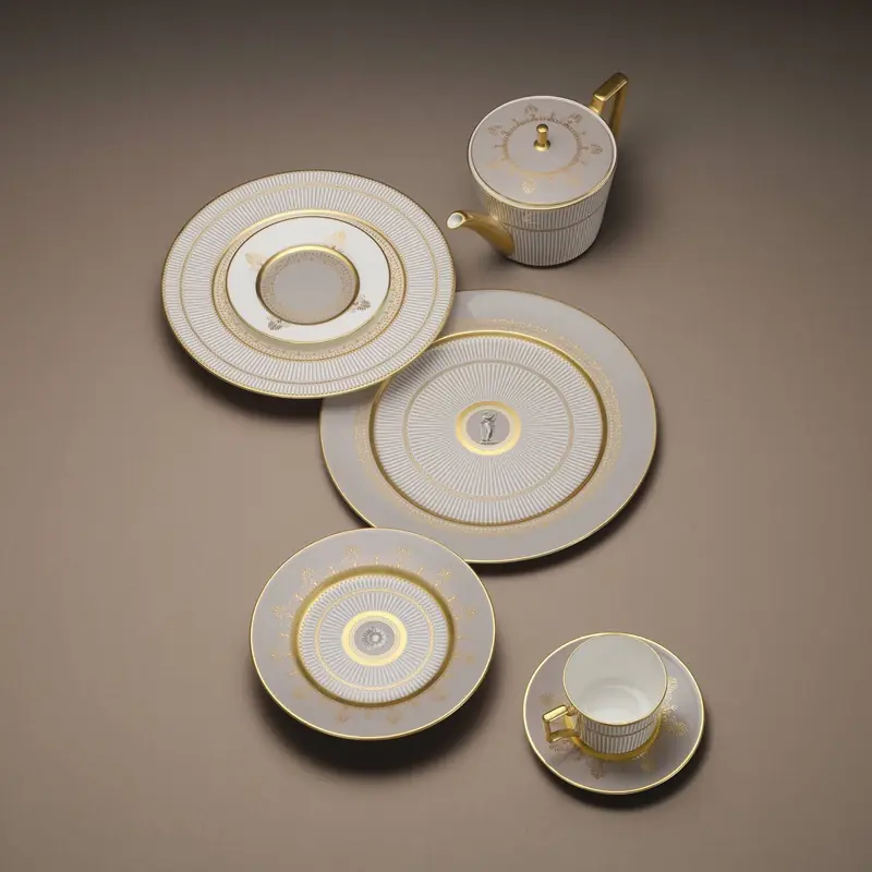 A stack of cream ceramic dinner plates on a stone table